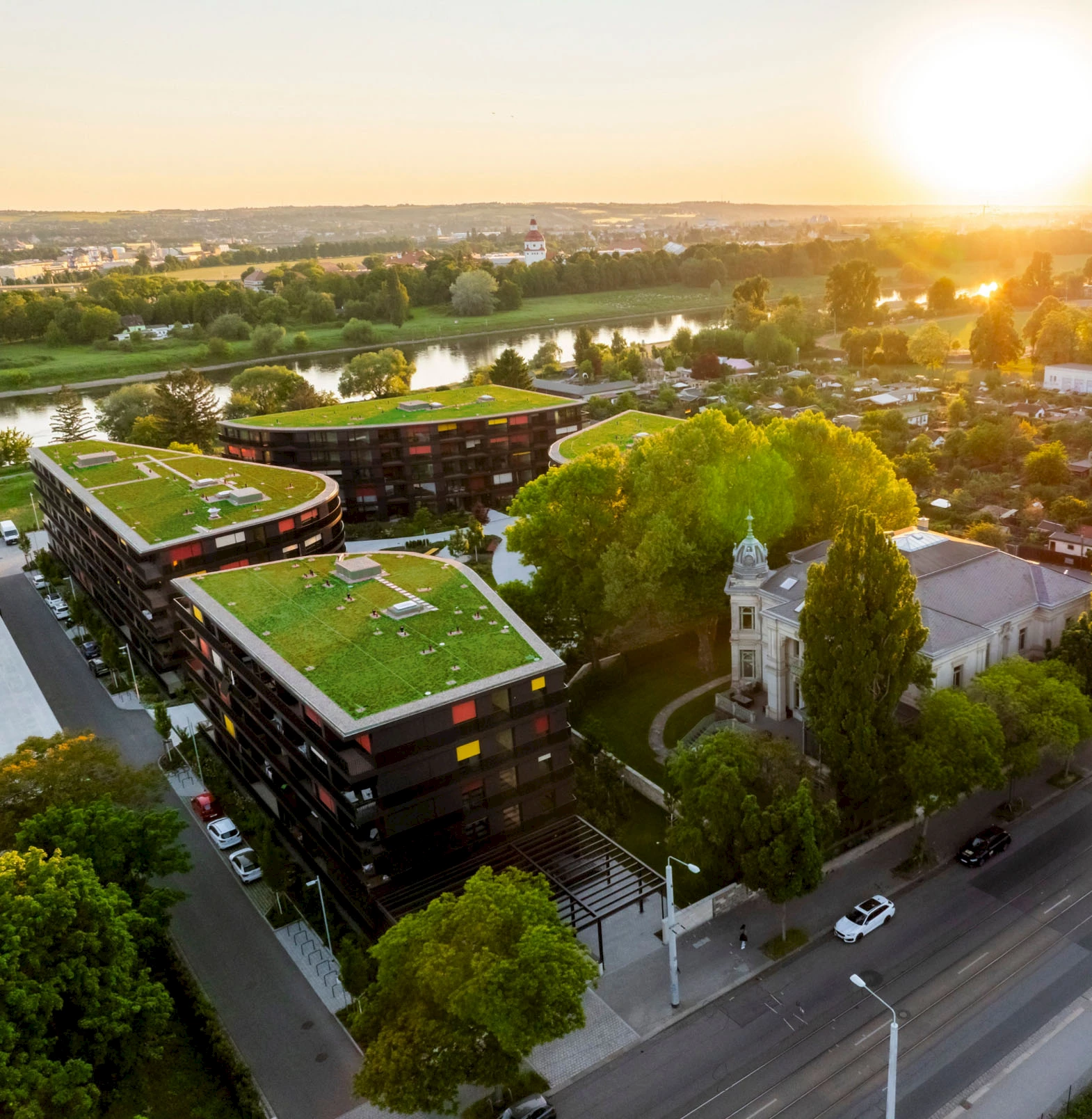 Luftaufnahme des Wohnprojekts Marina Garden in Dresden bei Sonnenuntergang mit der Elbe im Hintergrund