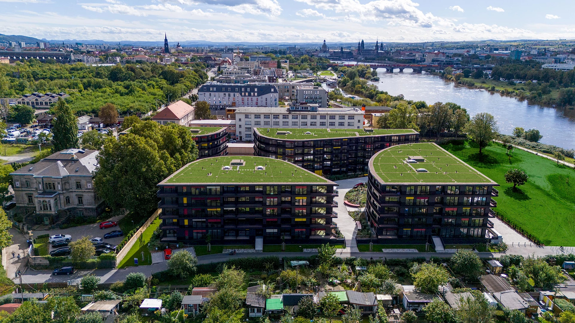 Luftaufnahme des Wohnprojekts Marina Garden in Dresden bei Sonnenuntergang mit der Elbe im Hintergrund